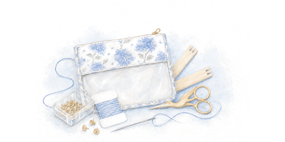 A needlepoint starter kit: hydrangea project bag, stretcher bars, tacks, thread, needle, and scissors