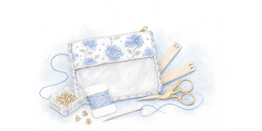 A needlepoint starter kit: hydrangea project bag, stretcher bars, tacks, thread, needle, and scissors