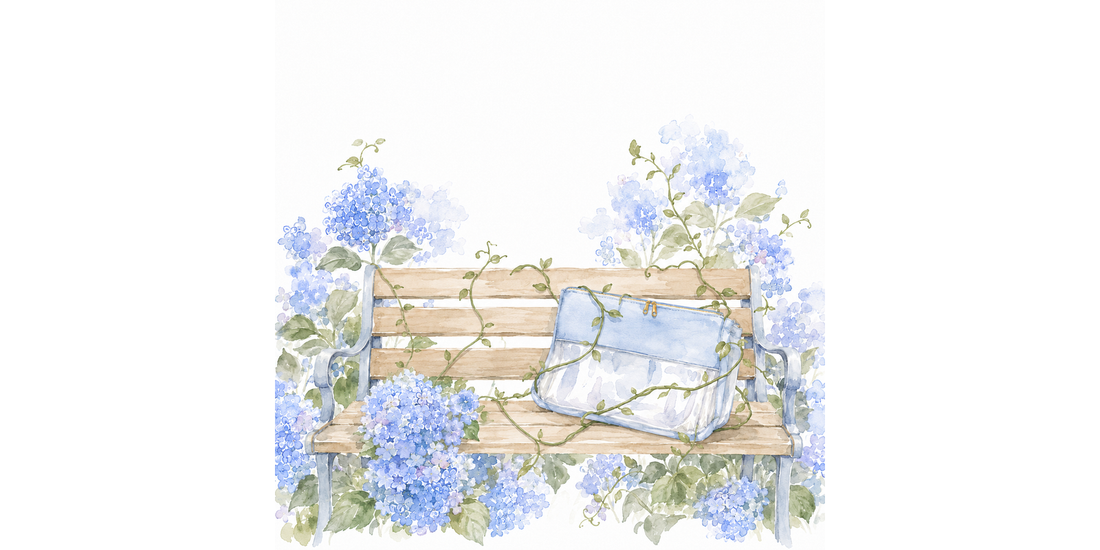 Watercolor of a blue needlepoint project bag resting on a garden bench among hydrangeas