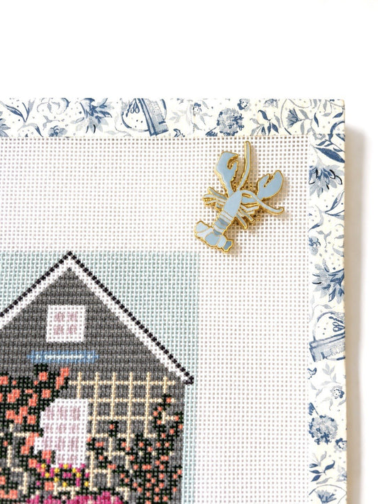 Sara Fitz blue lobster enamel needleminder on a needlepoint canvas