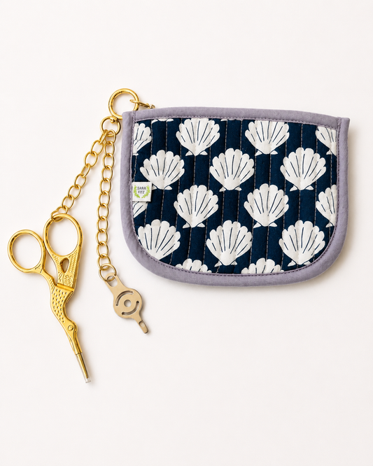 Sara Fitz quilted shells pouch with gold chain, gold stork embroidery scissors and a needle threader